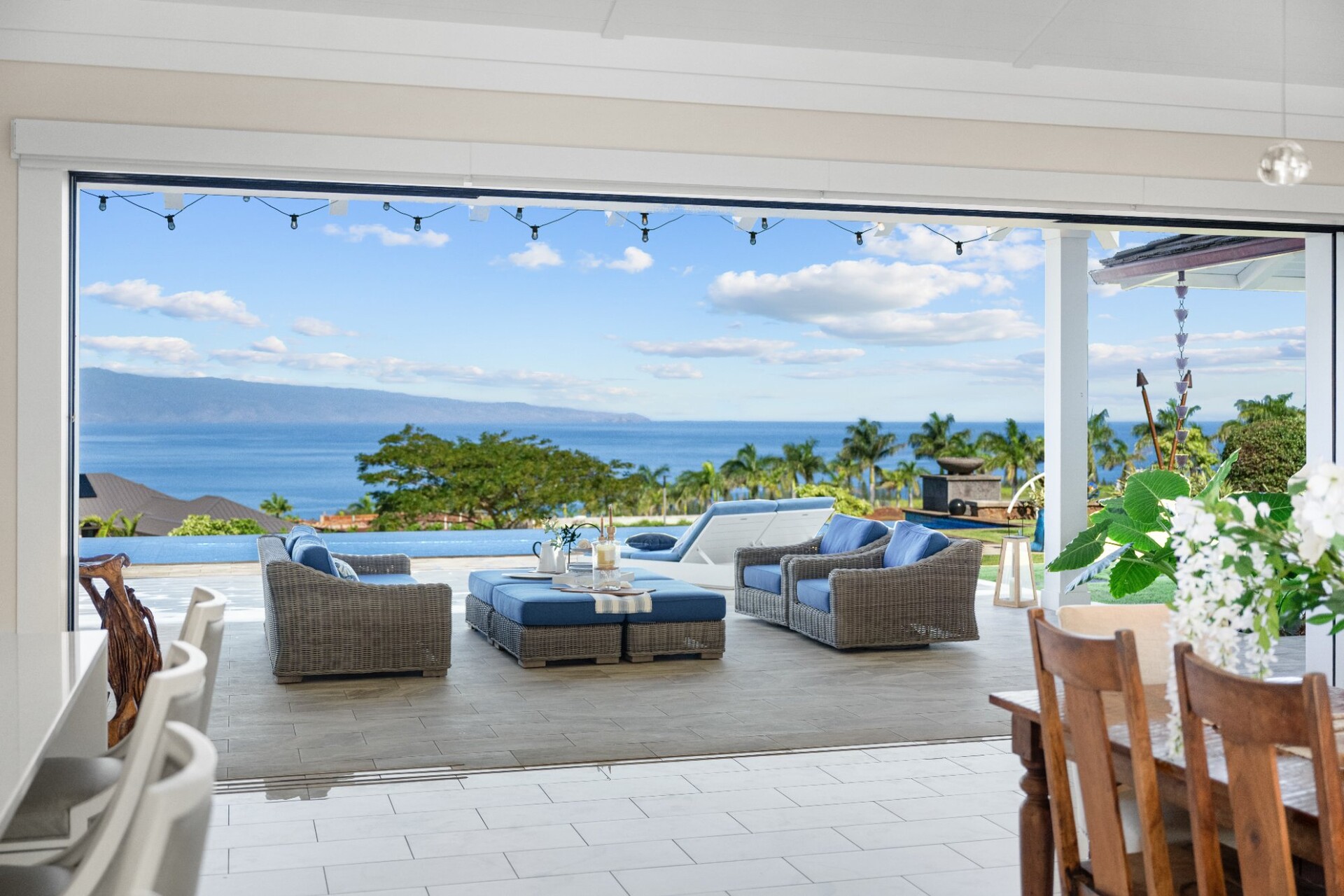 Indoor outdoor living space with pocket doors and Pacific Ocean views at 300 Mahana Ridge Kapalua luxury home